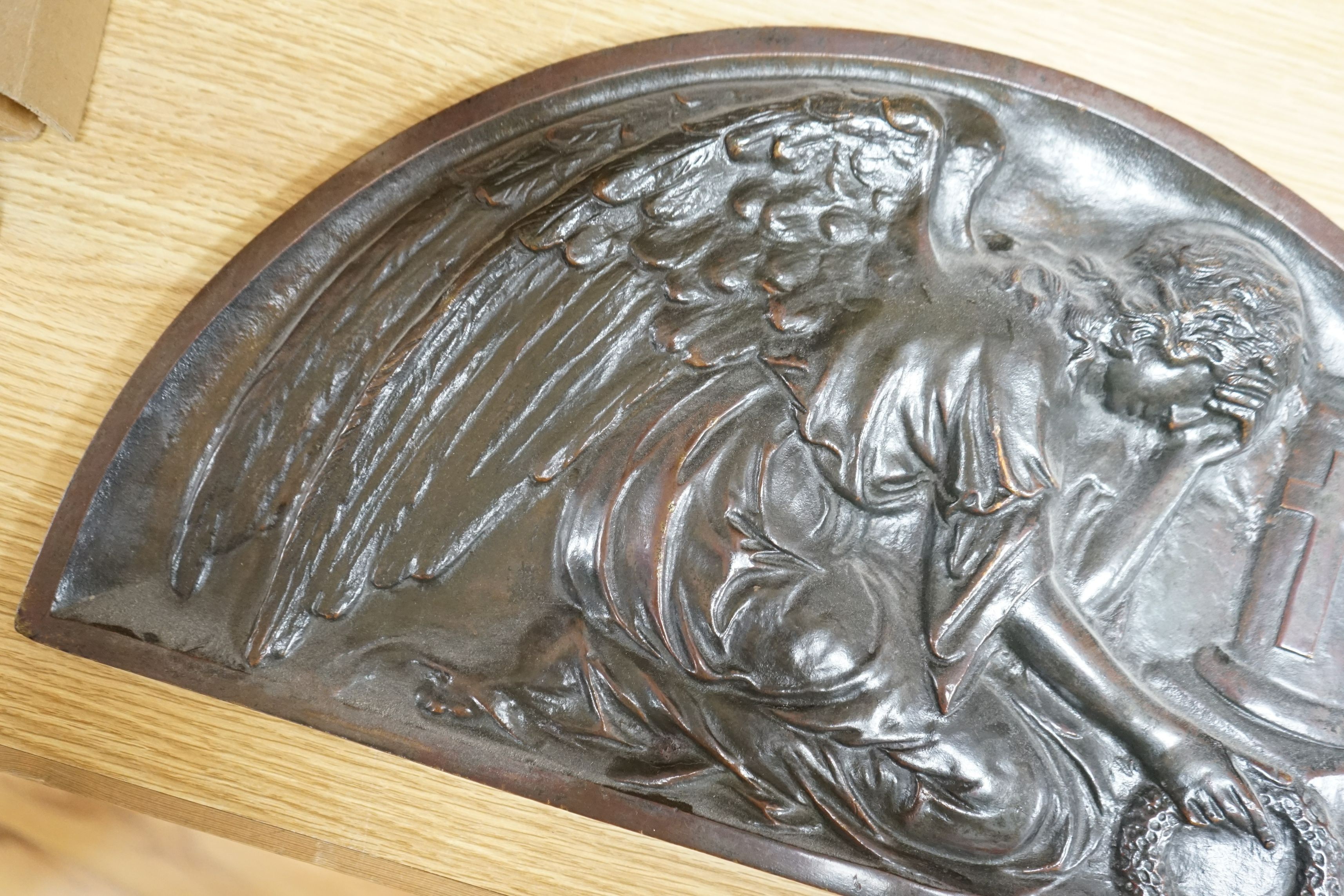 A demi-lune cast bronze panel depicting a weeping angel, signed DEBO, 49.5 x 26.5cm